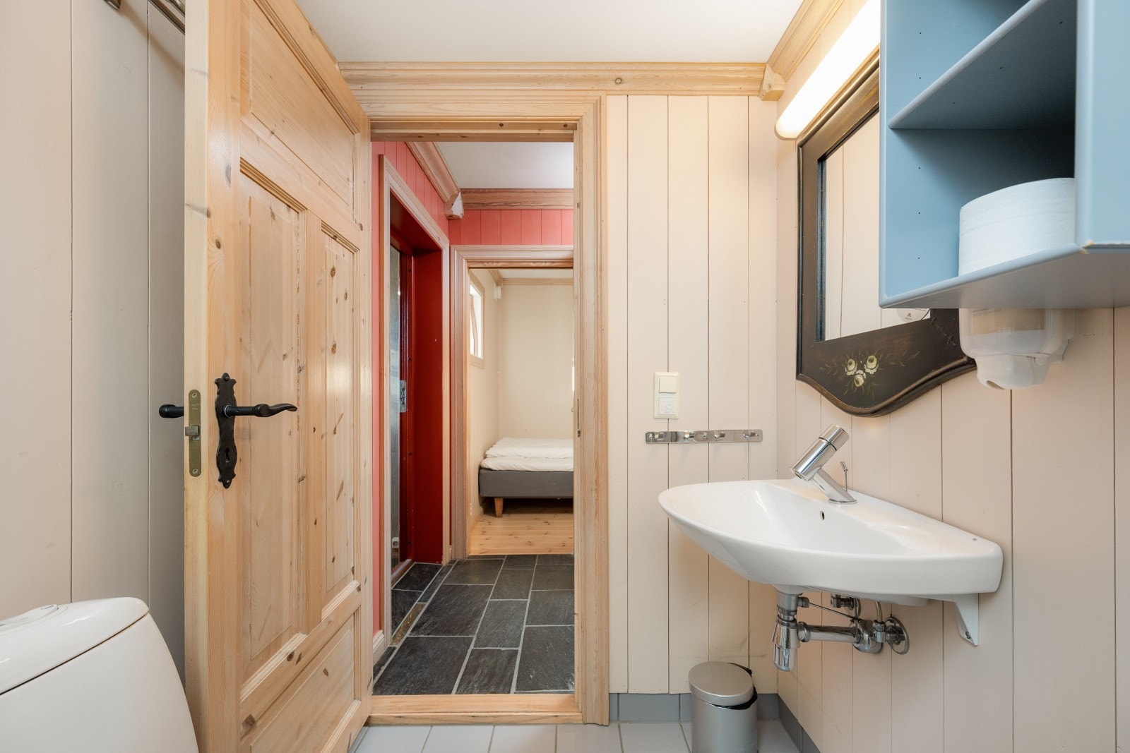 Gulvmontert toalett, servant, speil med belysning over, hylle og mekanisk avtrekk. Galleribilde