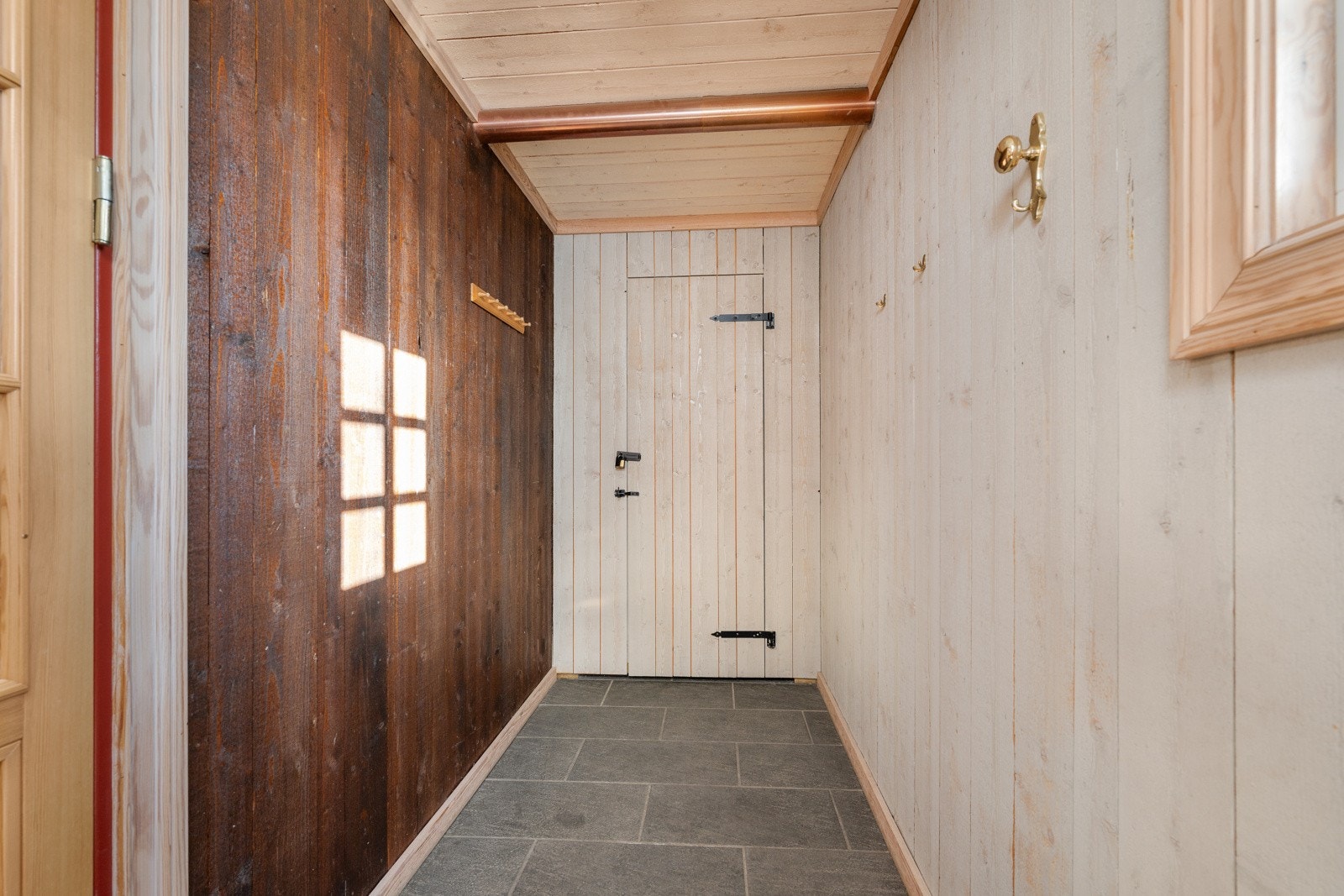 Praktisk gang med adkomst fra entréen. Bod/kott i enden av gangen gir muligheter for lagring av private eiendeler mellom utleieoppholdene. Galleribilde