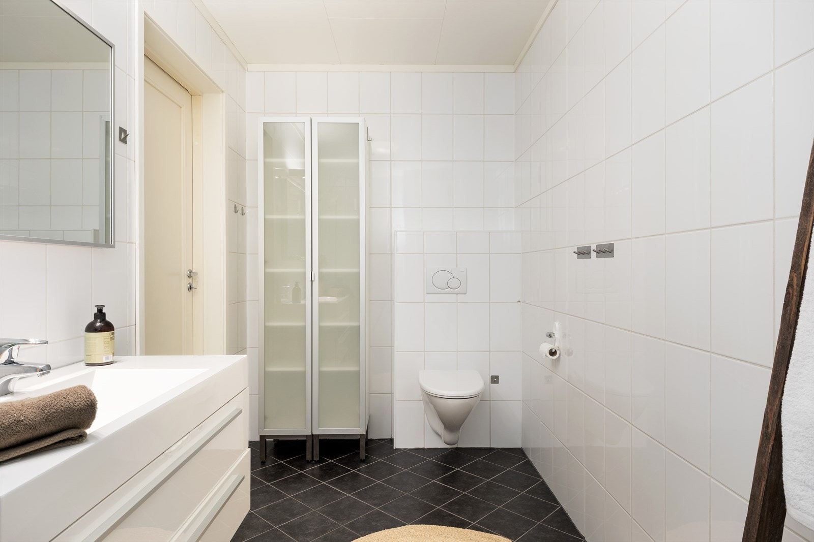 Underetasjen har eit kombinert bad og vaskerom med flis på golv og veggar. I taket er det tak-ess plater. Golvet har også elektriske varmekablar. Galleribilde