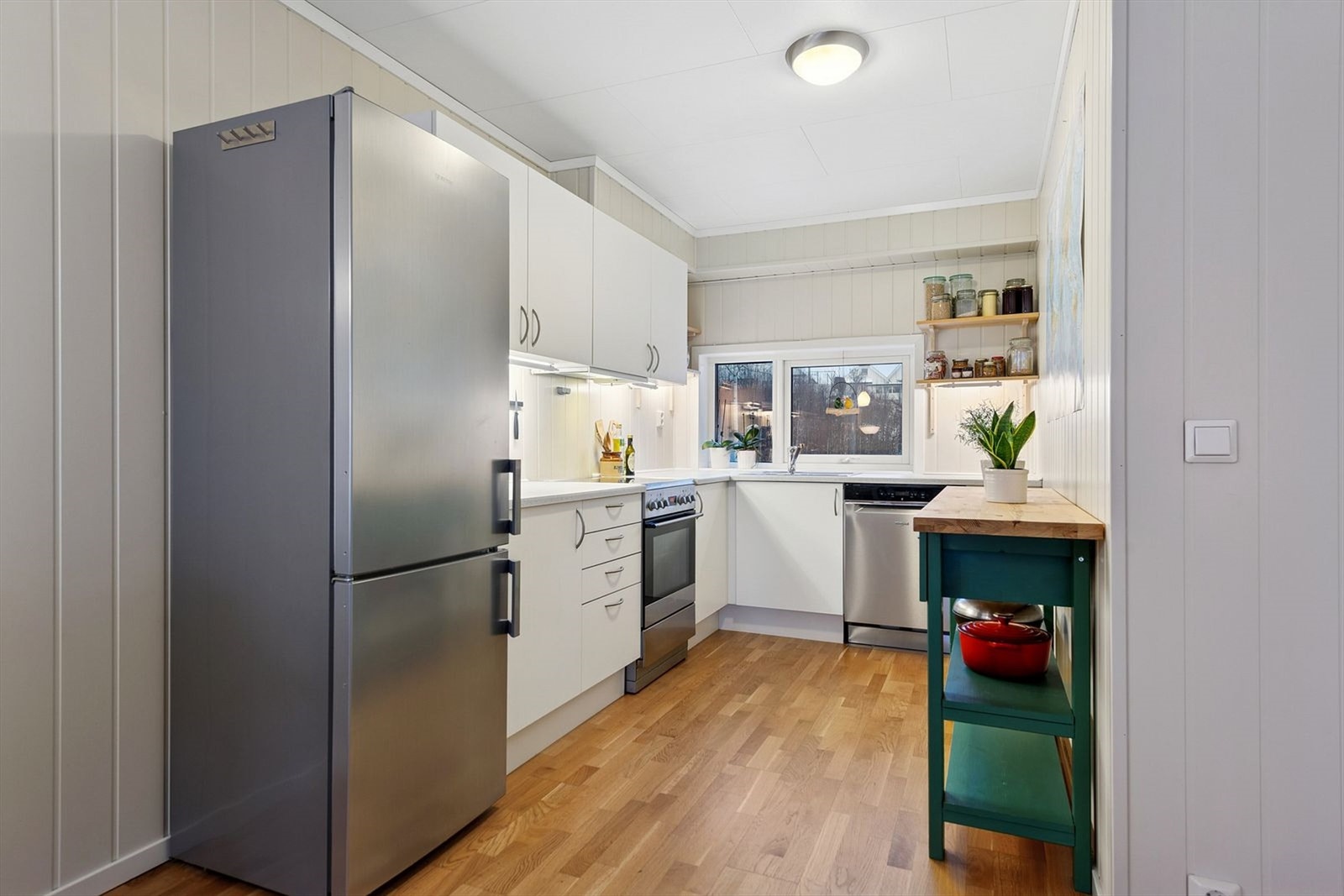 Kjøkkeninnredning med glatte fronter, laminatbenkeplate og godt med oppbevaringsplass. Galleribilde