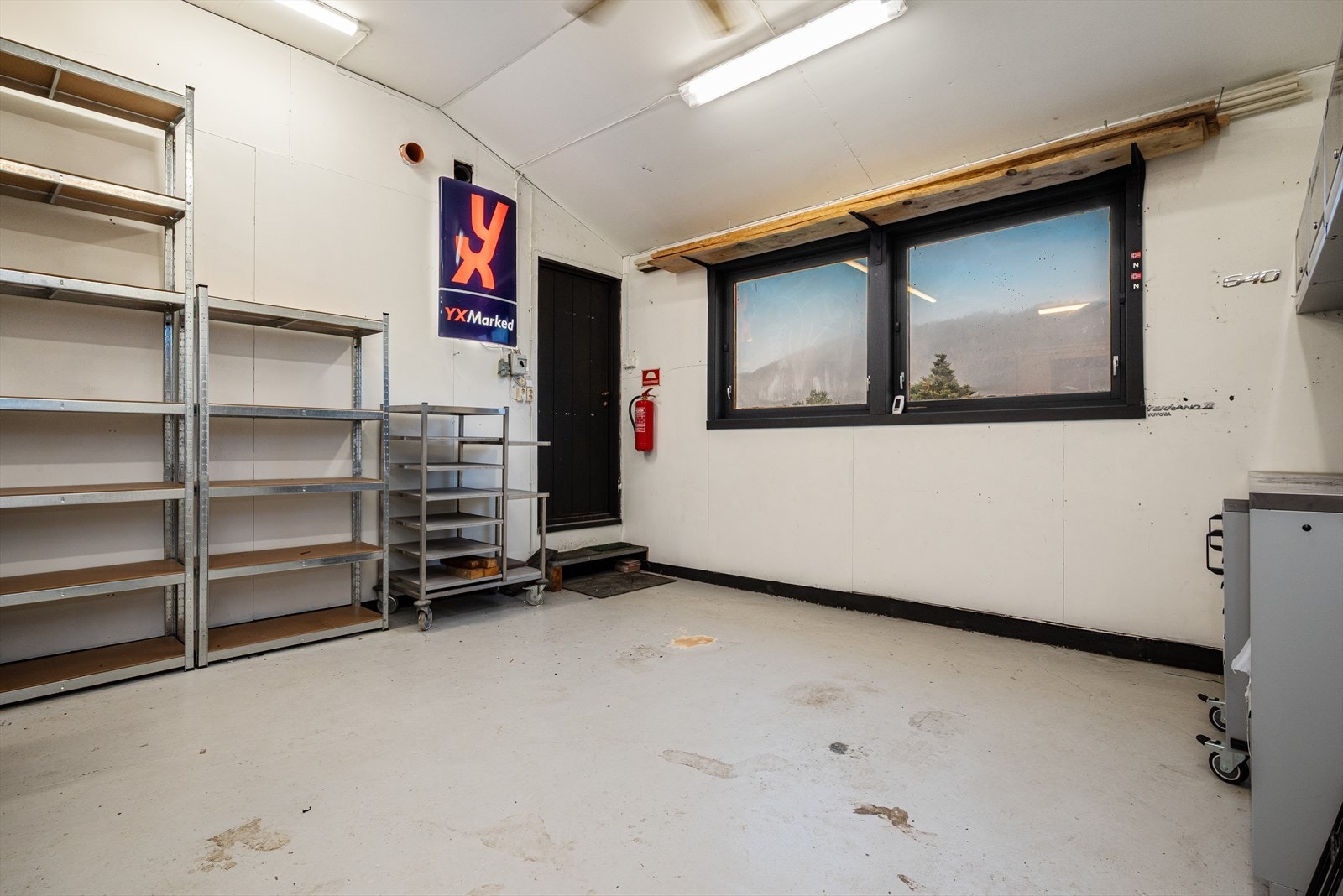 Fra balkong er det inngang til garasje/verksted i 1.etasje. Deler av vegg kan også demonteres for tilkomst fra utsiden. Her er det innlagt strøm, varmevifte på vegg tilknyttet vannbåren varme, dieseldrevet varmevifte på vegg og veggmontert svingkran. Galleribilde