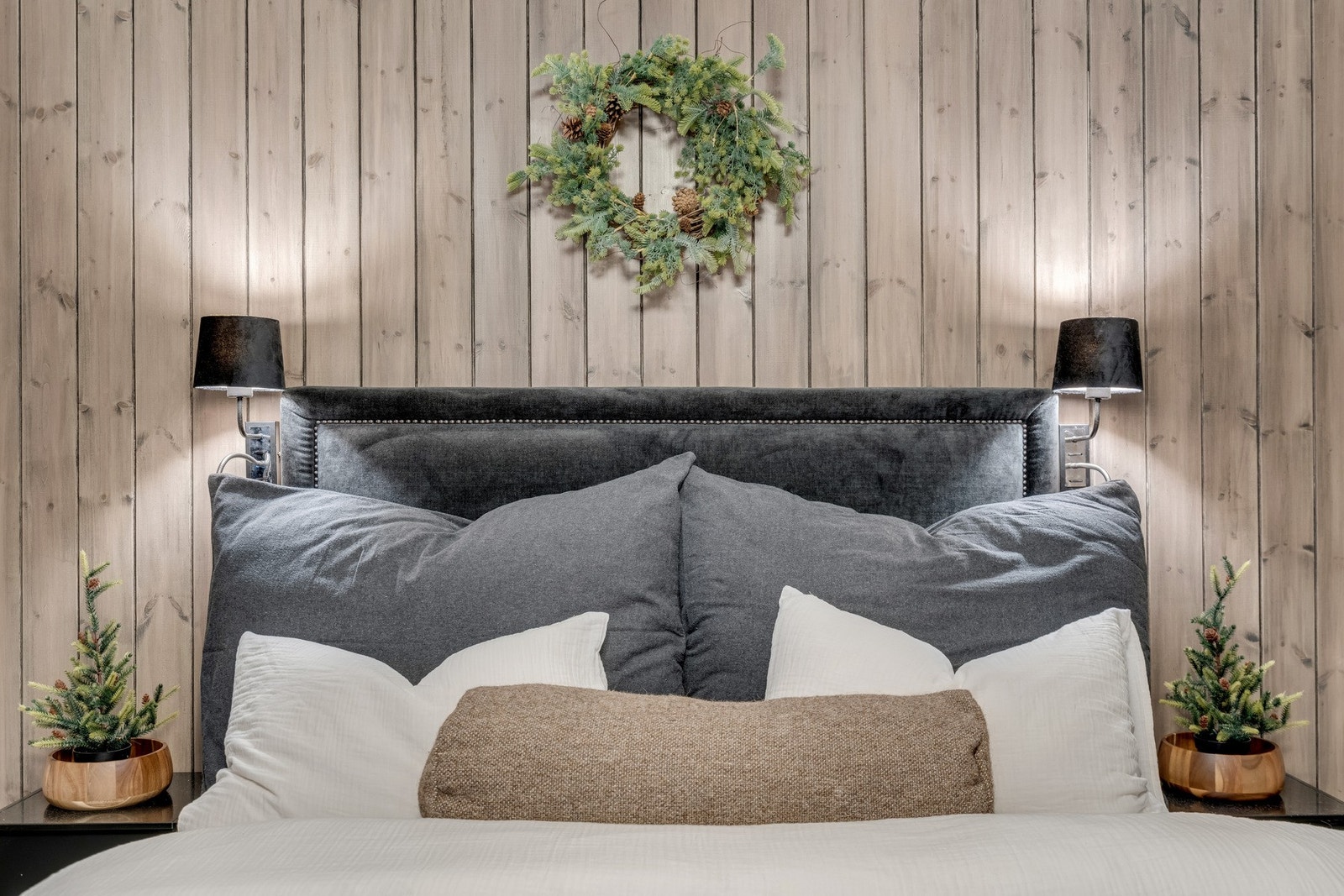 Soverom med nattbord, stemningsfulle lys og en elegant panelvegg - en lun og stilfull atmosfære. Galleribilde