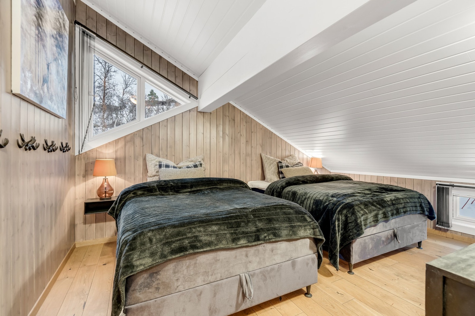 To romslige dobbeltsenger i 2. etasje, supplert med et fint vindu som slipper inn rikelig med naturlig lys - en kombinasjon av komfort og stil. Galleribilde