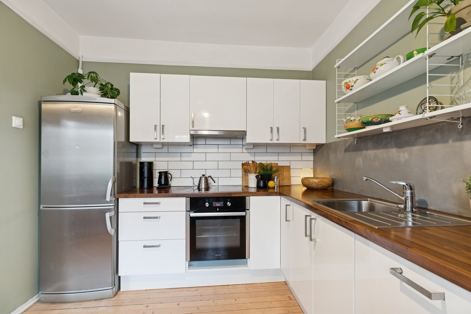 Kjøkkenet fra 2012 har en stilren innredning med fabrikk-lakkerte, glatte fronter som gir et tidløst og elegant uttrykk. Galleribilde