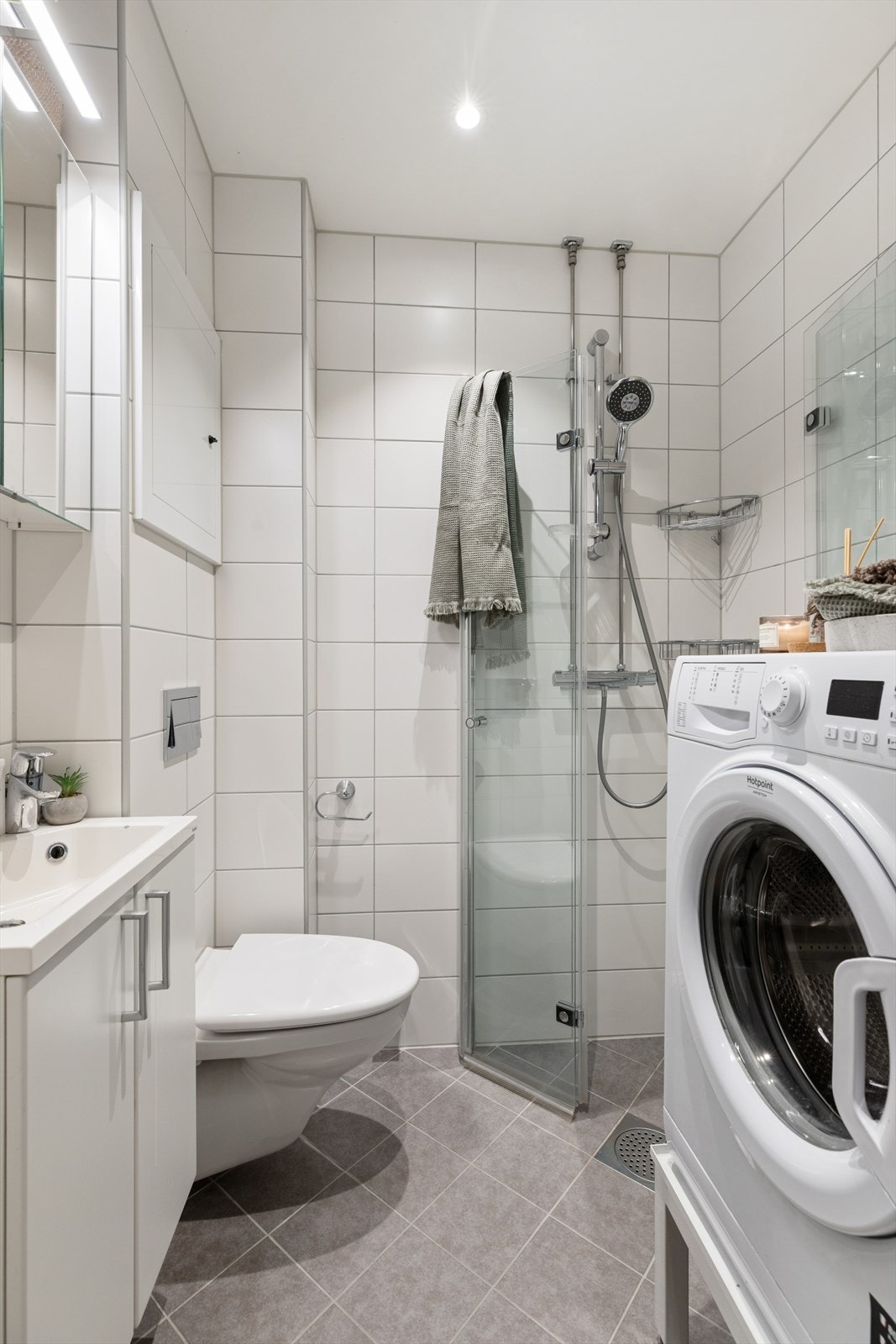 Flislagt bad med gulvvarme, speilskap og opplegg for vaskemaskin fra 2019. Galleribilde