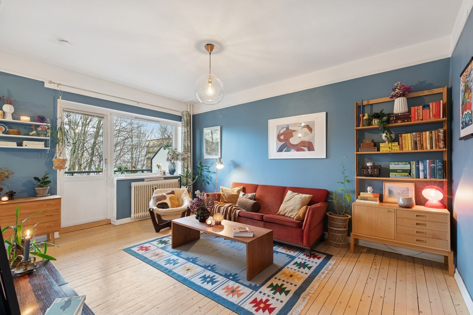 Romslig stue med lune farger og utgang til balkong. Galleribilde