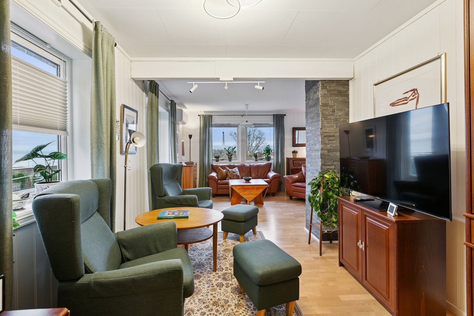 Stuen har store vindusoverflater som slipper inn rikelig med dagslys som skaper en hjemmekoselig følelse. Galleribilde