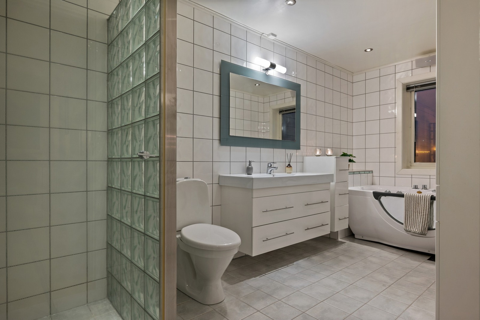 Badet har gjennomført materialvalg og god komfort med varmekabler i gulv. Galleribilde