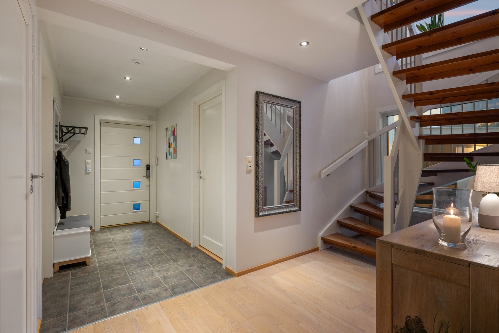 Åpen og luftig entrésone med trappeløp som knytter etasjene sammen på en elegant måte. Galleribilde