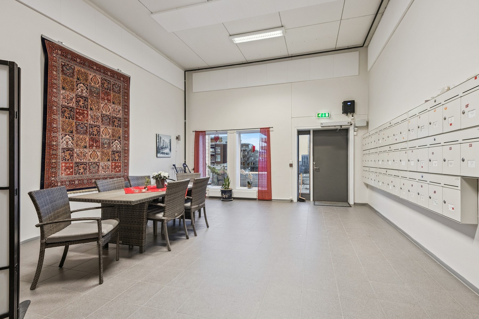 Innenfor inngangsdøra til leilighetsbygget er det et hyggelig fellesareal som brukes til sosiale lag i borettslaget. Galleribilde