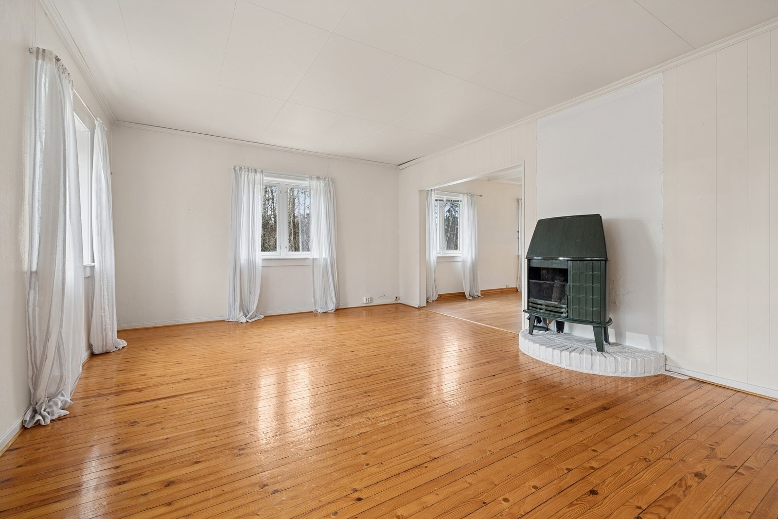 Rommet gir god plass til å innrede en hyggelig TV-stue, med naturlig lys fra flere vinduer og en klassisk peis som skaper ekstra atmosfære. Galleribilde