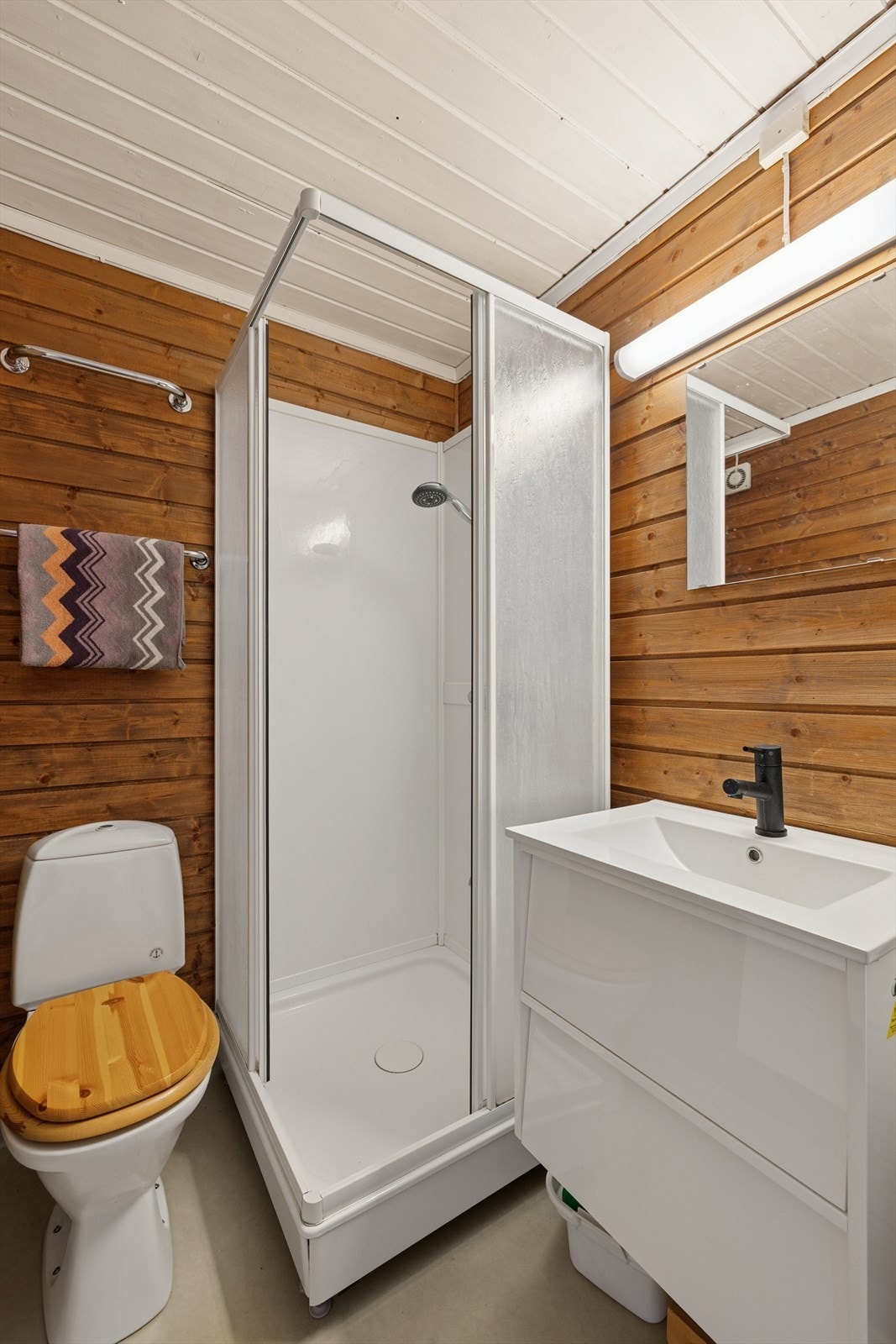 Baderommet er moderne og funksjonelt innredet med toalett, servant med underskap, speil og praktisk dusjkabinett, og tilbyr både komfort og smarte løsninger i hverdagen. Galleribilde