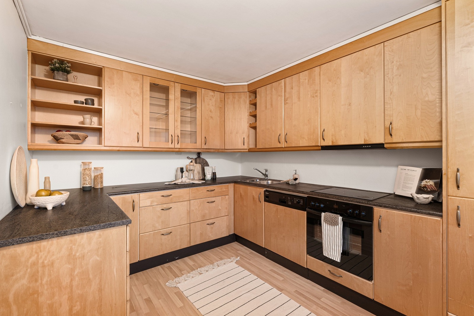 Romslig kjøkken med en funksjonell utforming med god skap- og benkeplass. Galleribilde