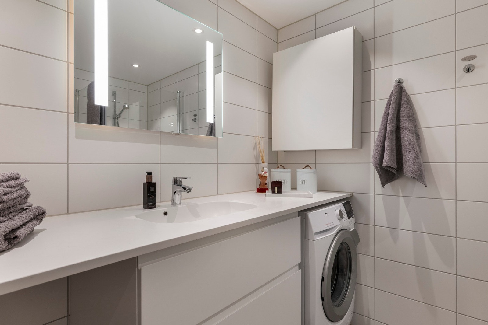 Innredningen består av en servant med slette fronter og skuffer, veggmontert toalett og opplegg til vaskemaskin Galleribilde