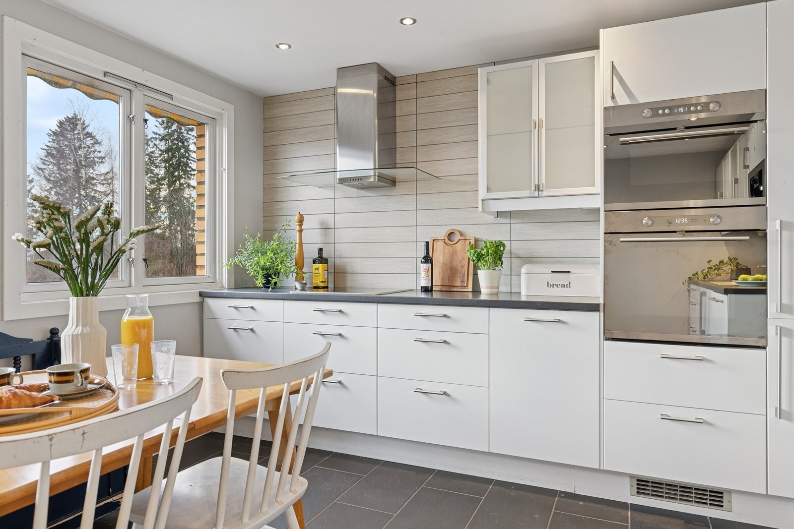 Kjøkkeninnredning med glatte, tidløse fronter og belysning i overskap. Galleribilde