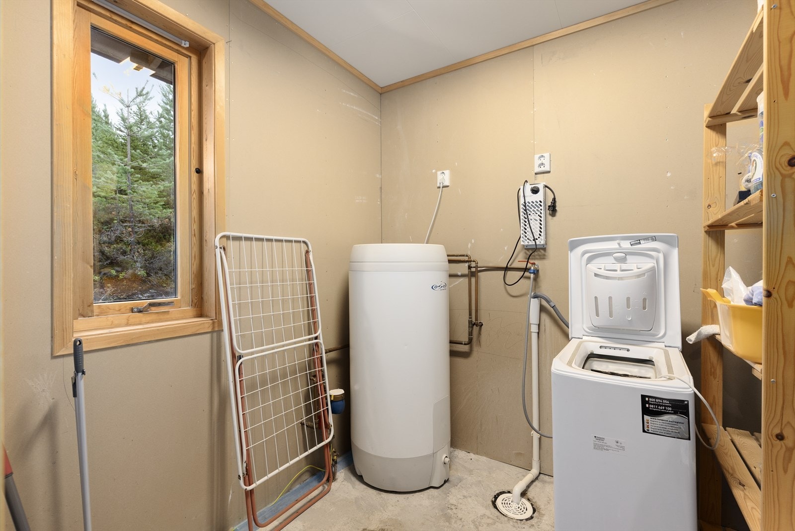 Fra entré er det tilkomst til vaskerommet som inneholder varmtvannstank fra OSO på ca. 200 liter fra 2016 og opplegg til vaskemaskin. Galleribilde