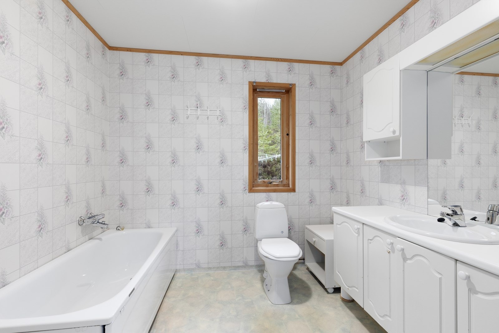 Badet ligger praktisk til i gangen og inneholder servant med underskap, overskap, speil, lys, gulvmontert toalett, vegghengt dusj og badekar. Galleribilde