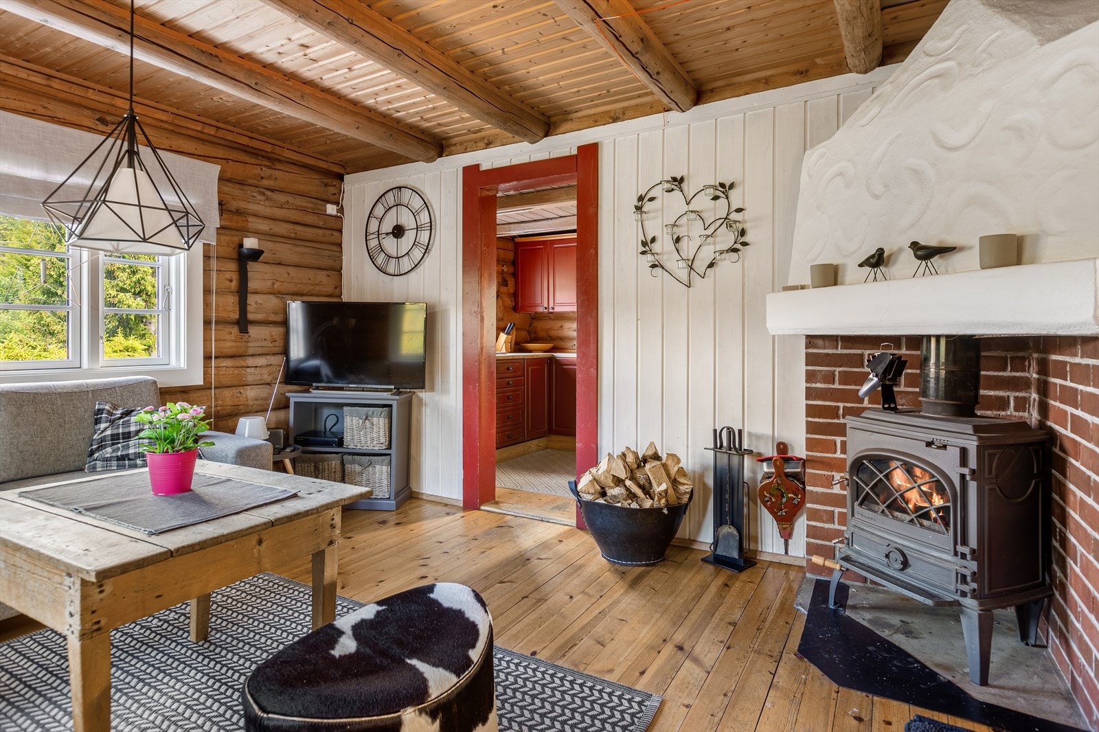 En åpen peis med innsatt peisovn sørger for god varme og en hyggelig stemning i rommet. Galleribilde