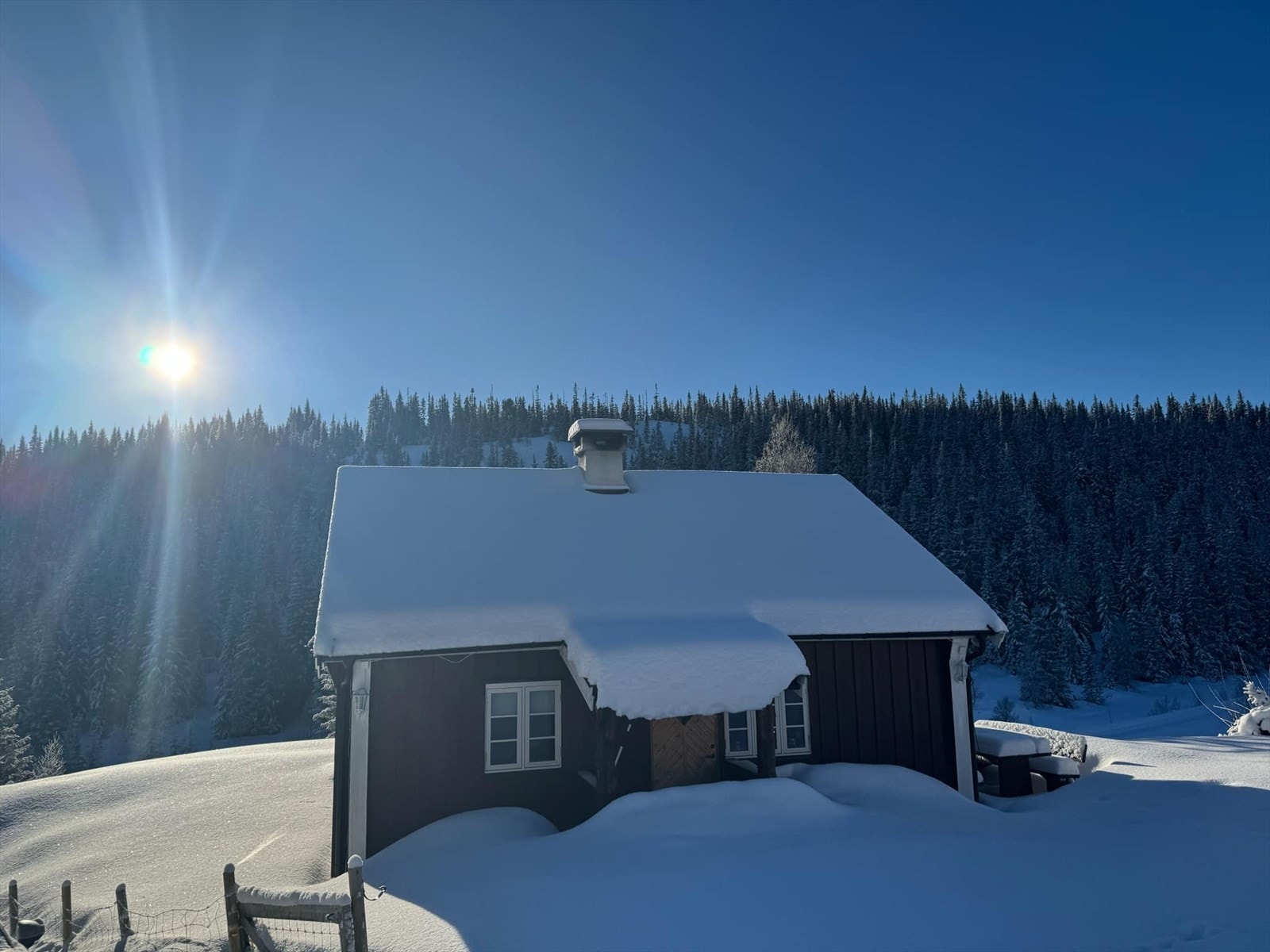 "Fredbu" som eiendommen heter, ligger oppå en liten kolle med flott utsikt utover området og til elva Bøvi, som en finner ca 50 m. fra hytta. (Selgers foto) Galleribilde