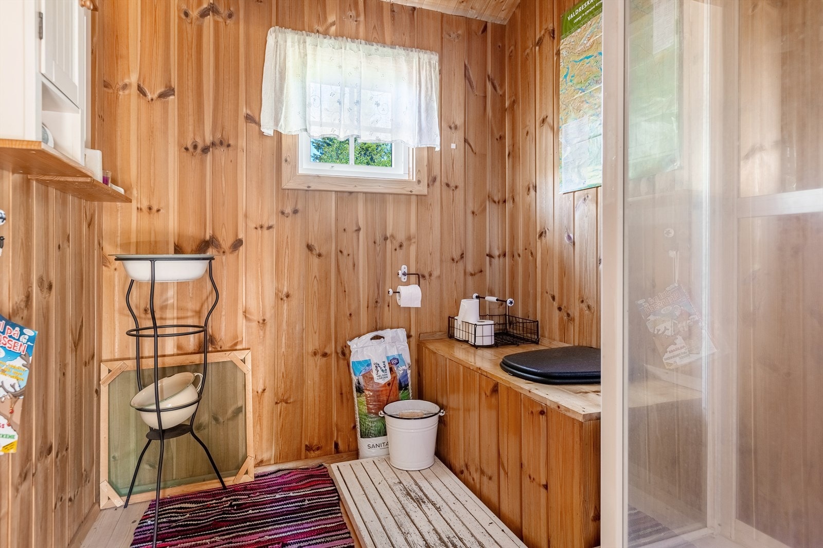 Annekset har egen inngang til bod og til "hyttebad". Her finner en hyttedusj tilkoblet vannvarmer og sisterne, samt dobenk av tre. Galleribilde