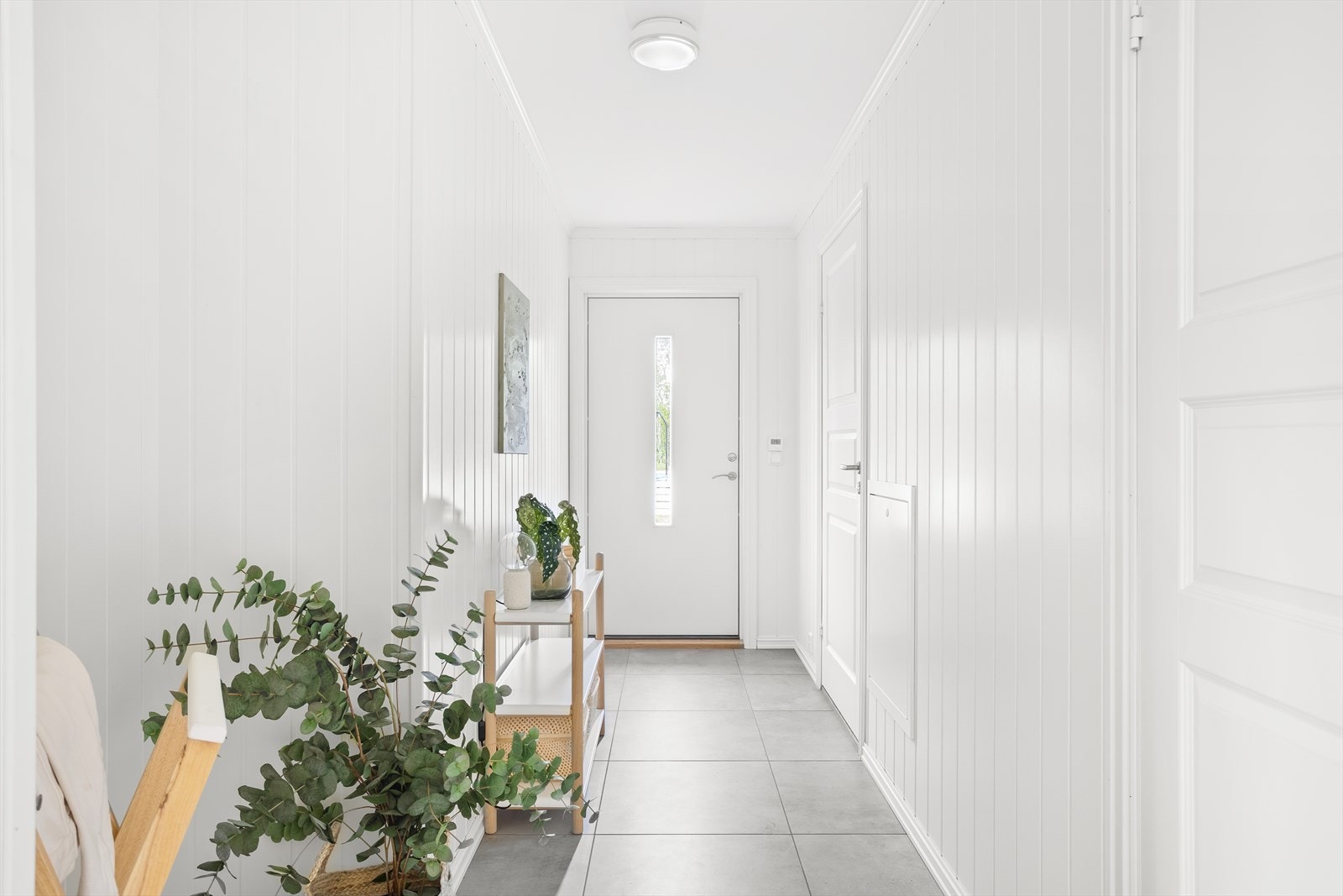 Innenfor inngangsdøren finnes en lys og delikat entré med fliser på gulvet. Galleribilde