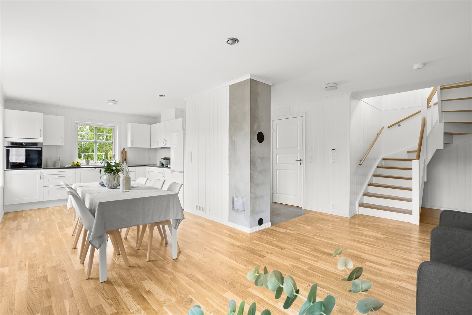 Bilde av stue og kjøkken med trappeoppgangen. Galleribilde