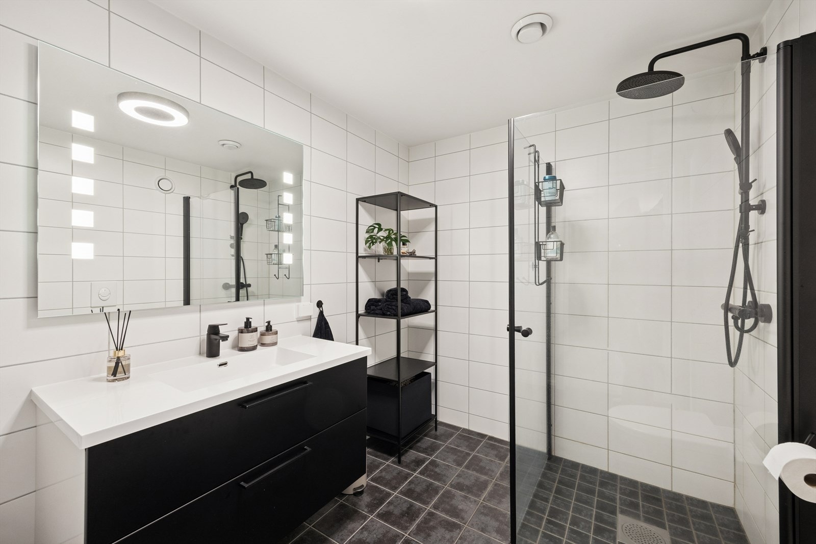 Det er innredet med: foliert servant med glatte fronter, speil på vegg over servant med lys, vegghengt klosett og dusjhjørne. Galleribilde