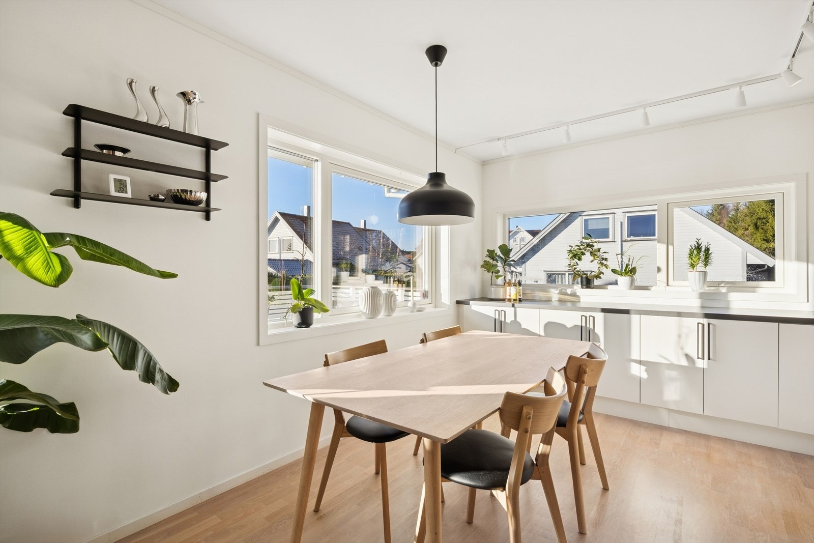 Kjøkkenet er stilrent med hvite glatte fronter og mørk benkeplate. Galleribilde