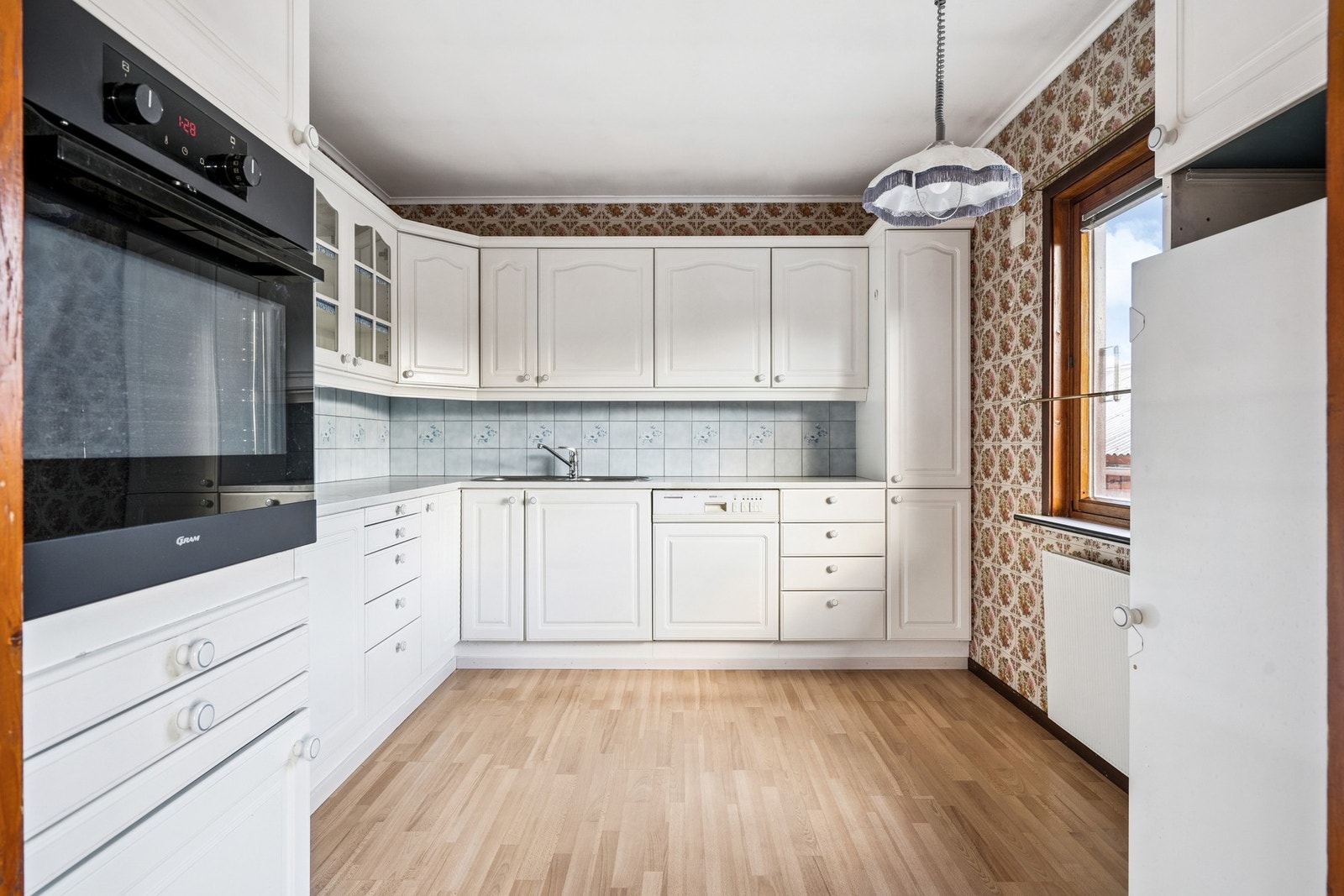 Lyst kjøkkeninnredning med laminat benkeplate. Galleribilde