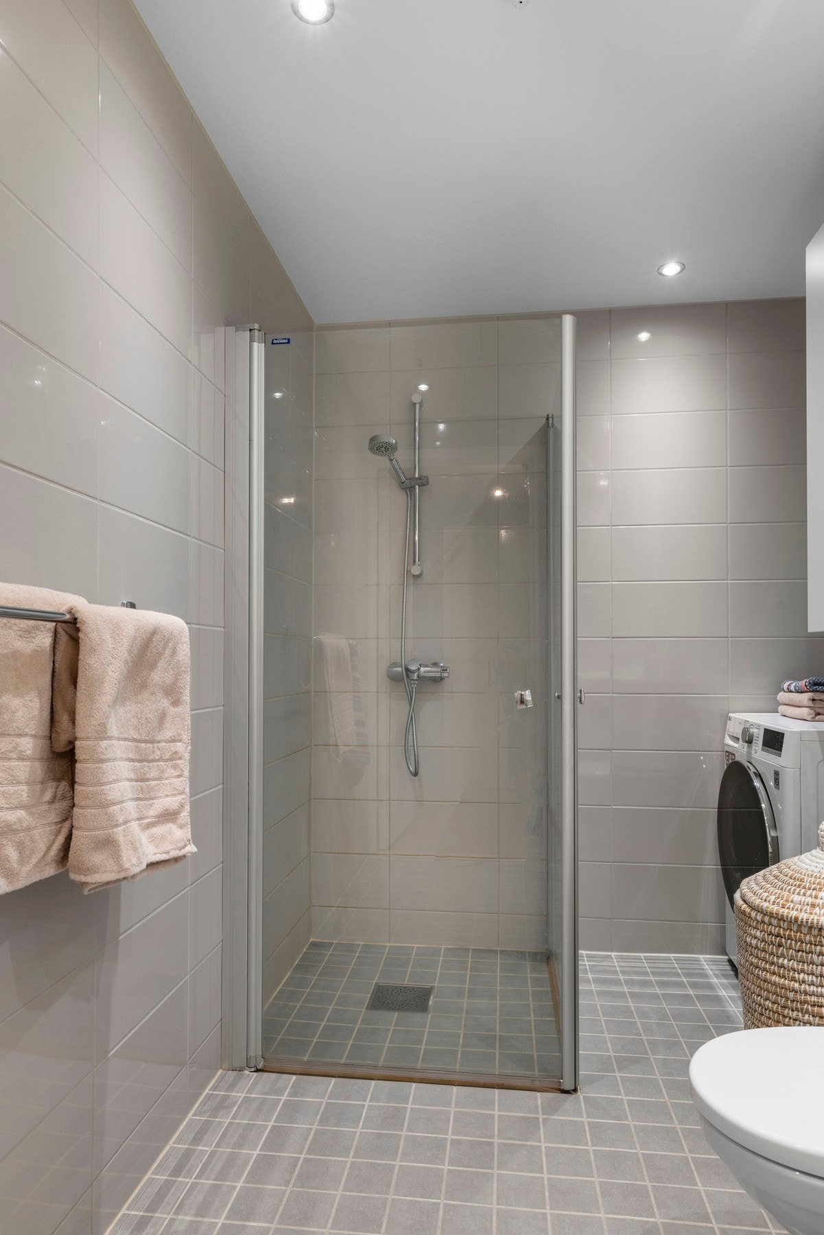 Rommet har veggmontert toalett med utenpåliggende sisterne og dusjhjørne med to stk svingbare glassdører Galleribilde