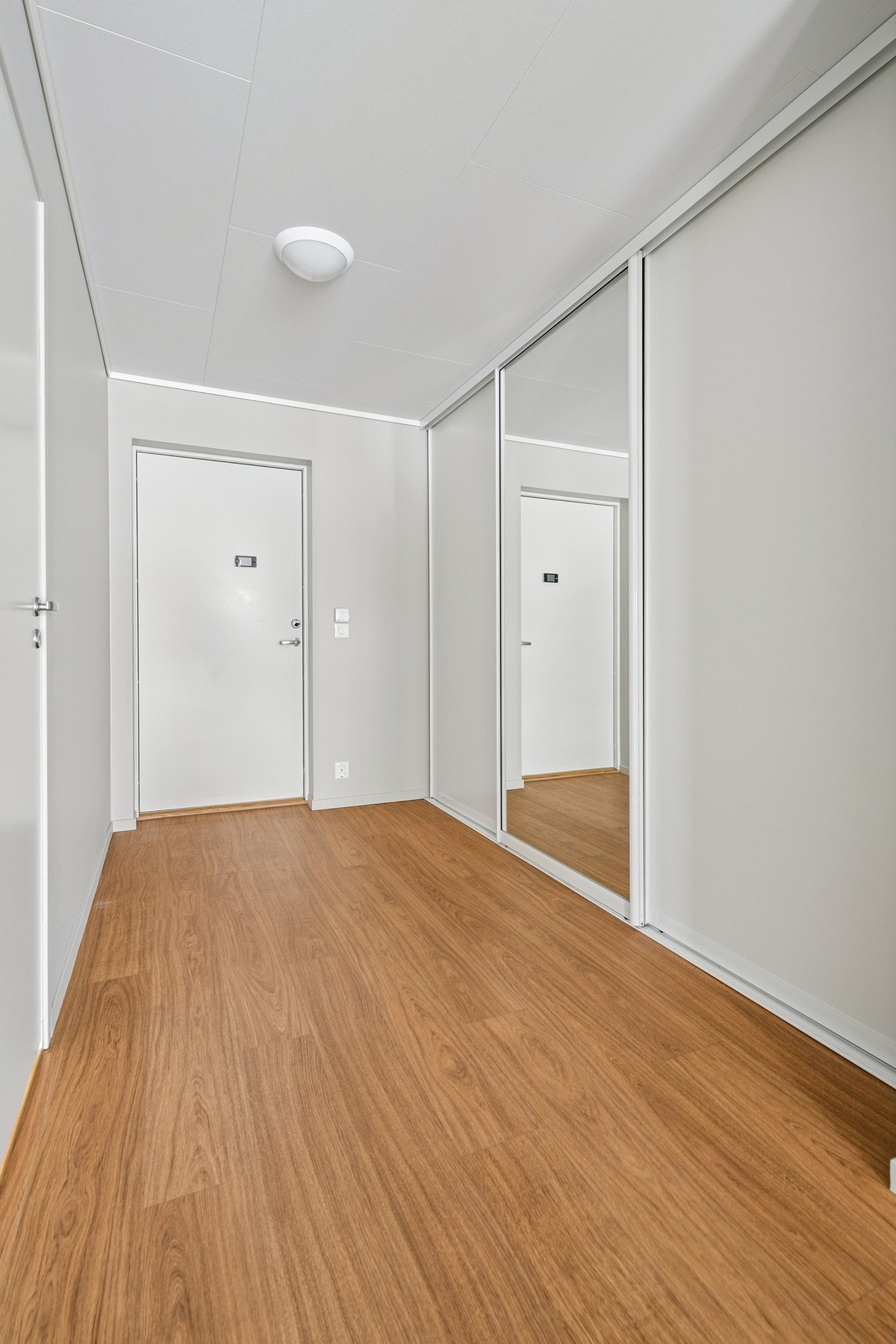 Romslig inngangsparti med praktisk skyvedørsgarderobe. Galleribilde