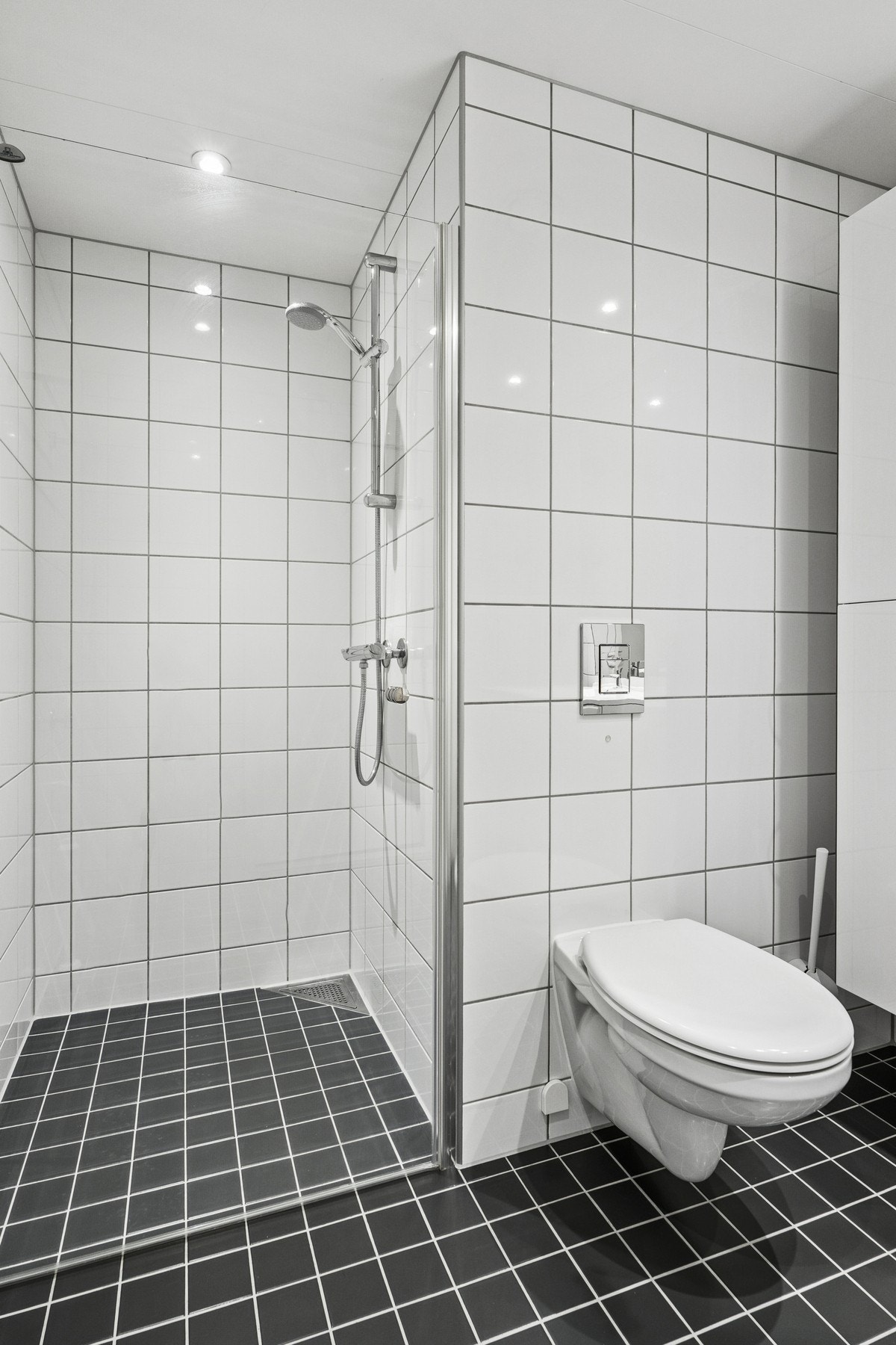 Badet er stilrent med dusjnisje og vegghengt servant. Galleribilde