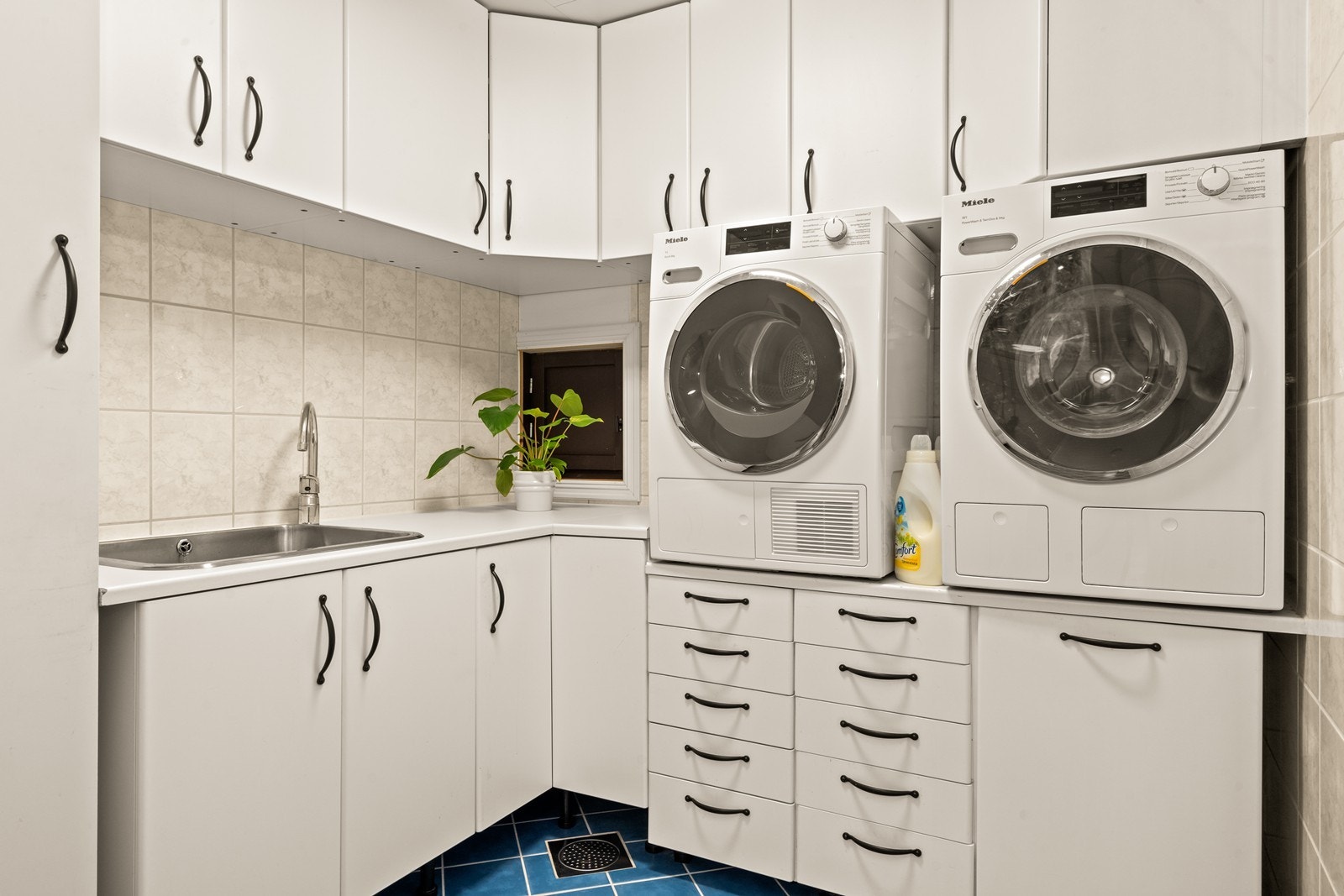 Vaskerommet har flislagte overflater og elektriske varmekabler som gir en komfortabel temperatur. Skapinnredningen har slette, lyse fronter og laminert arbeidsbenk med nedfelt vaskekum. Galleribilde