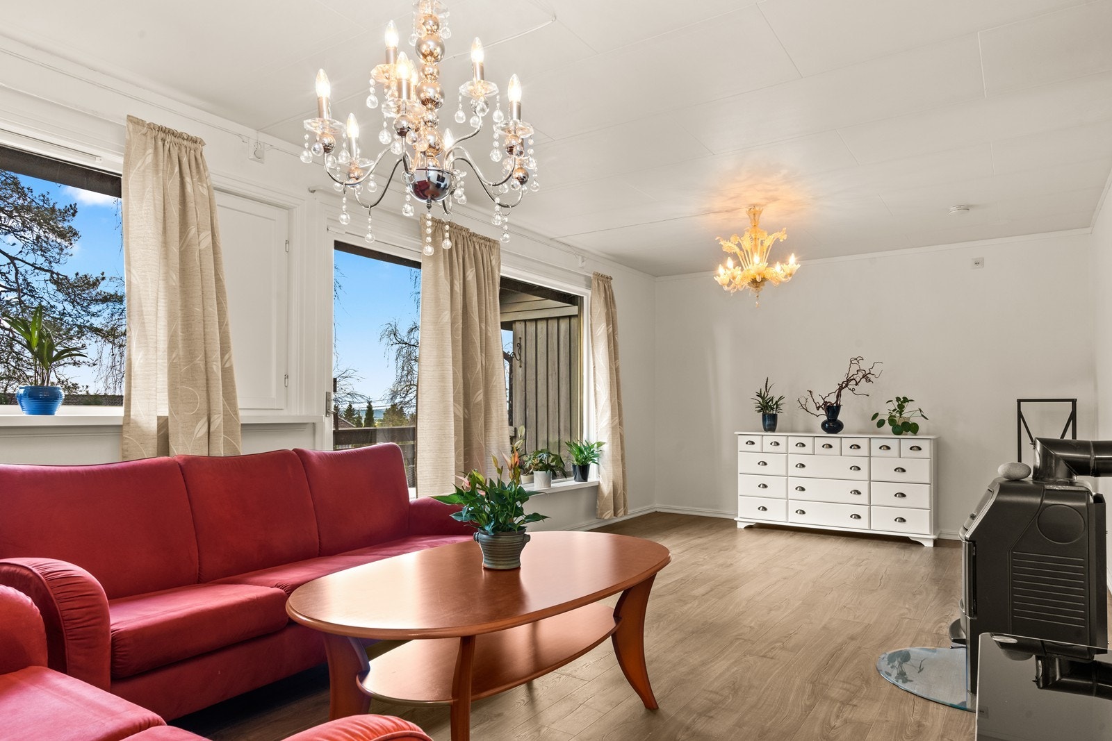 Vedovn i stuen gir effektiv oppvarming og hyggelig stemning. Laminatgulv og malte veggplater skaper et praktisk og enkelt vedlikeholdt rom. Galleribilde