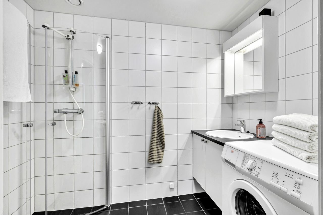 Pent, flislagt bad med vaskemaskin Galleribilde