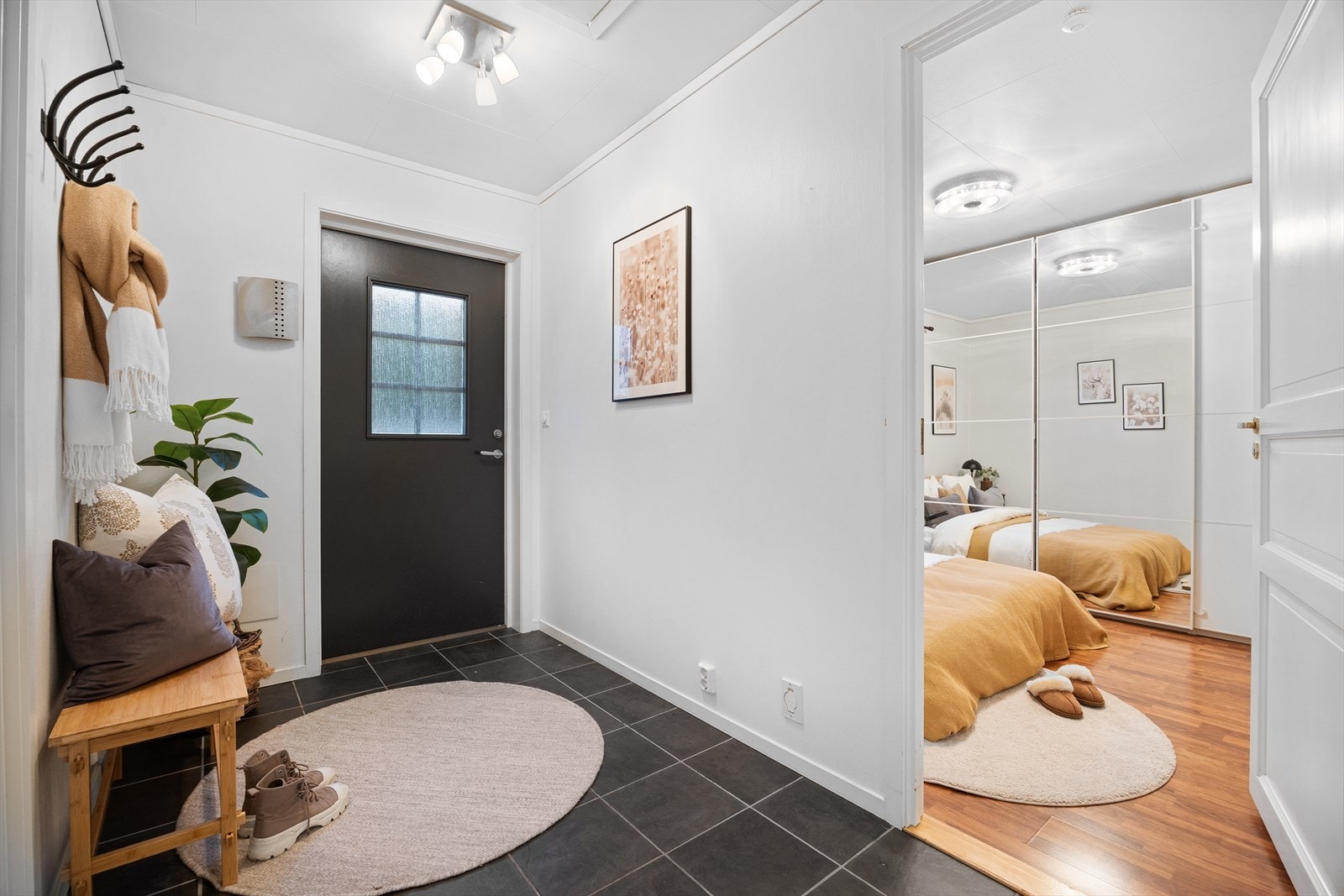 Velkommen inn i en trivelig entrè med fliser på gulv og lyse overflater. Her er det god plass til å henge fra seg yttertøy og sette fra seg sko. Galleribilde