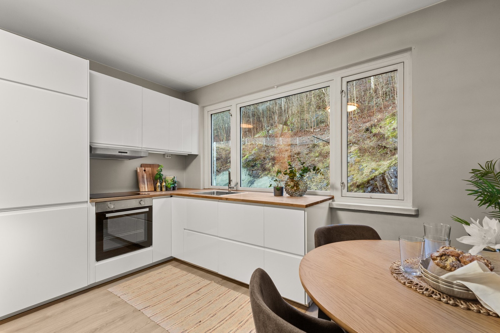 Integrerte hvitevarer bestående av stekeovn, nedfelt induksjonstopp, oppvaskmaskin og kjøl/frys. Galleribilde