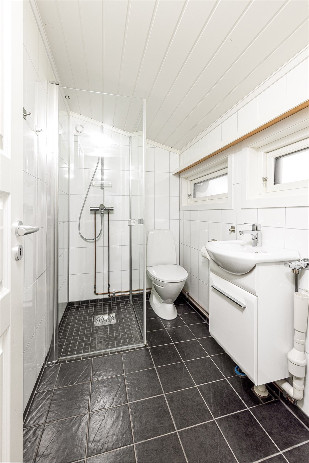 Flislagt bad med varmekabler fra 2018. Badet er utstyrt med dusjhjørne, wc, servant og opplegg for vaskemaskin Galleribilde