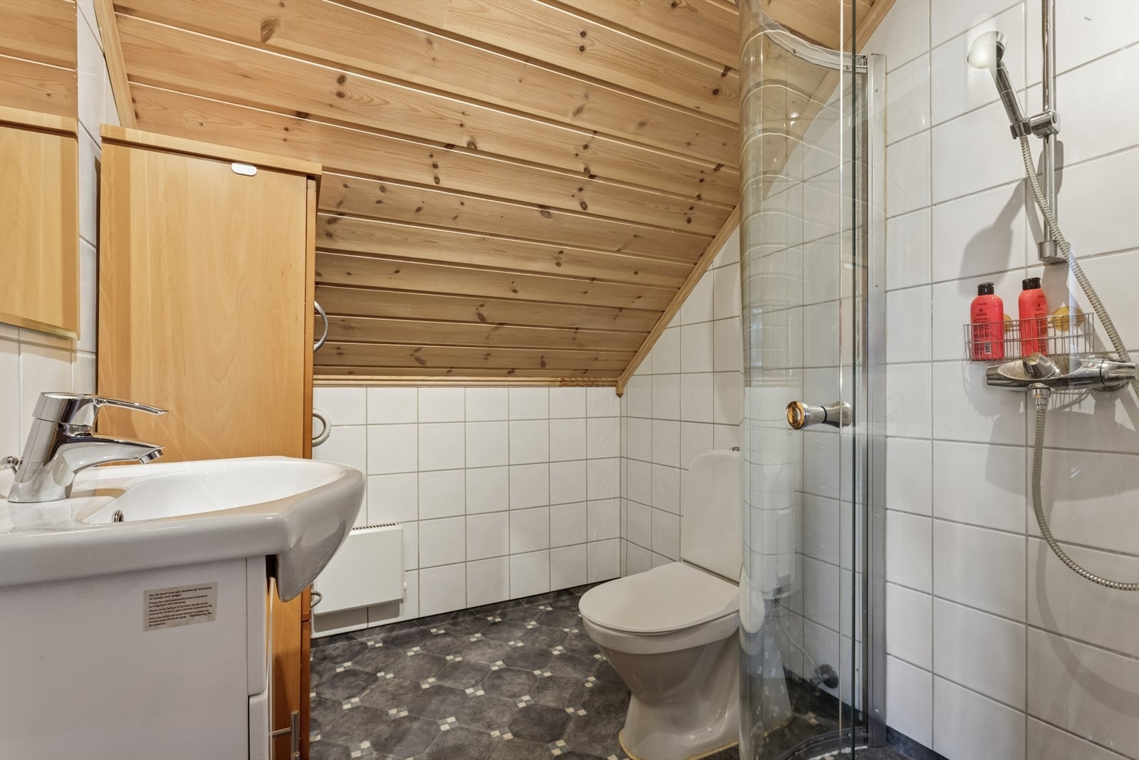 Bad i loftsetasje utstyrt med gulvstående toalett og en god baderomsinnredning. Galleribilde