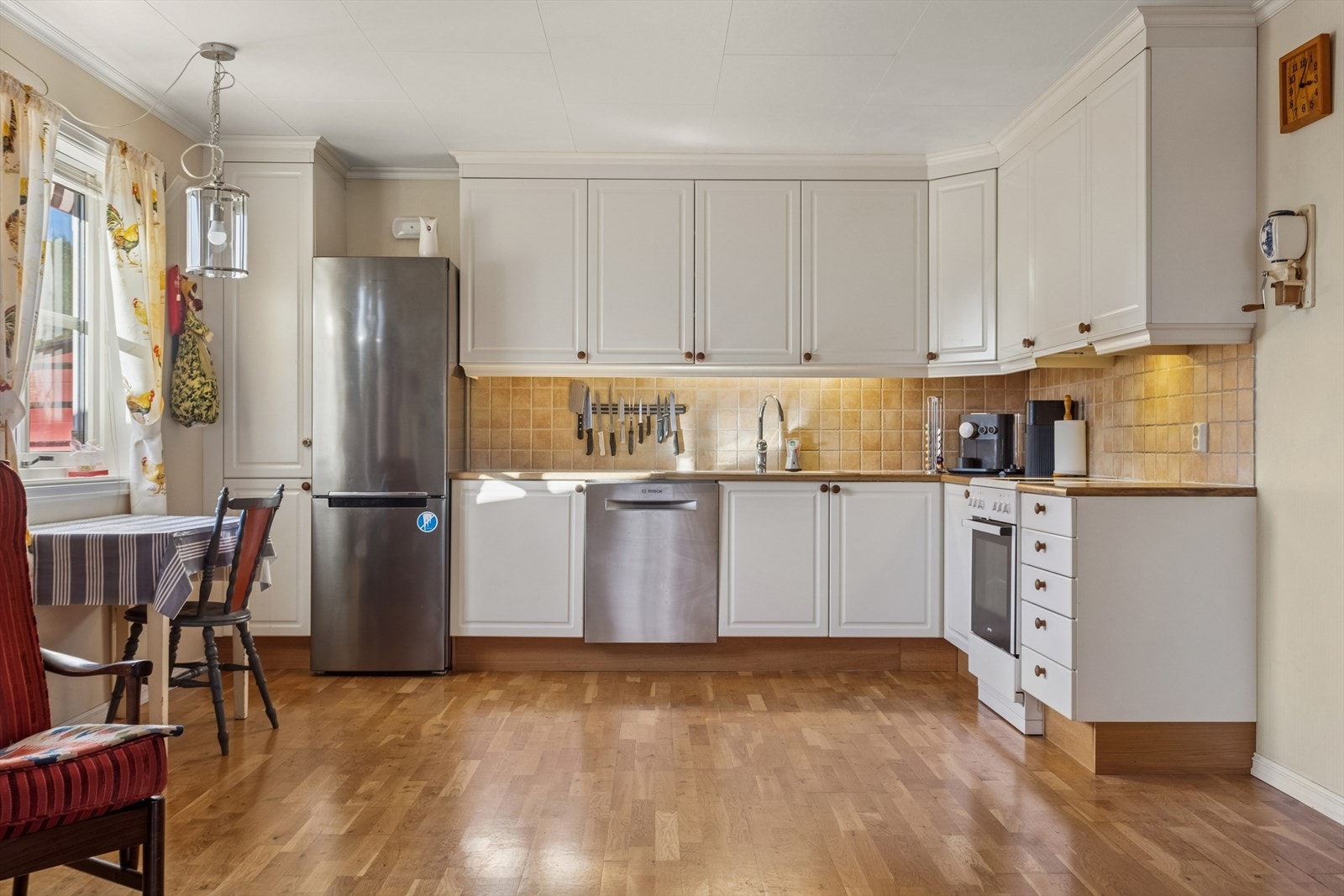 Lyst og tidløst kjøkken med alt en måtte trenge av skap-, skuff- og benkeplass. Frittstående hvitevarer som komfyr, oppvaskmaskin og kjøl/frys. Alt i alt et funksjonelt og godt kjøkken. Galleribilde