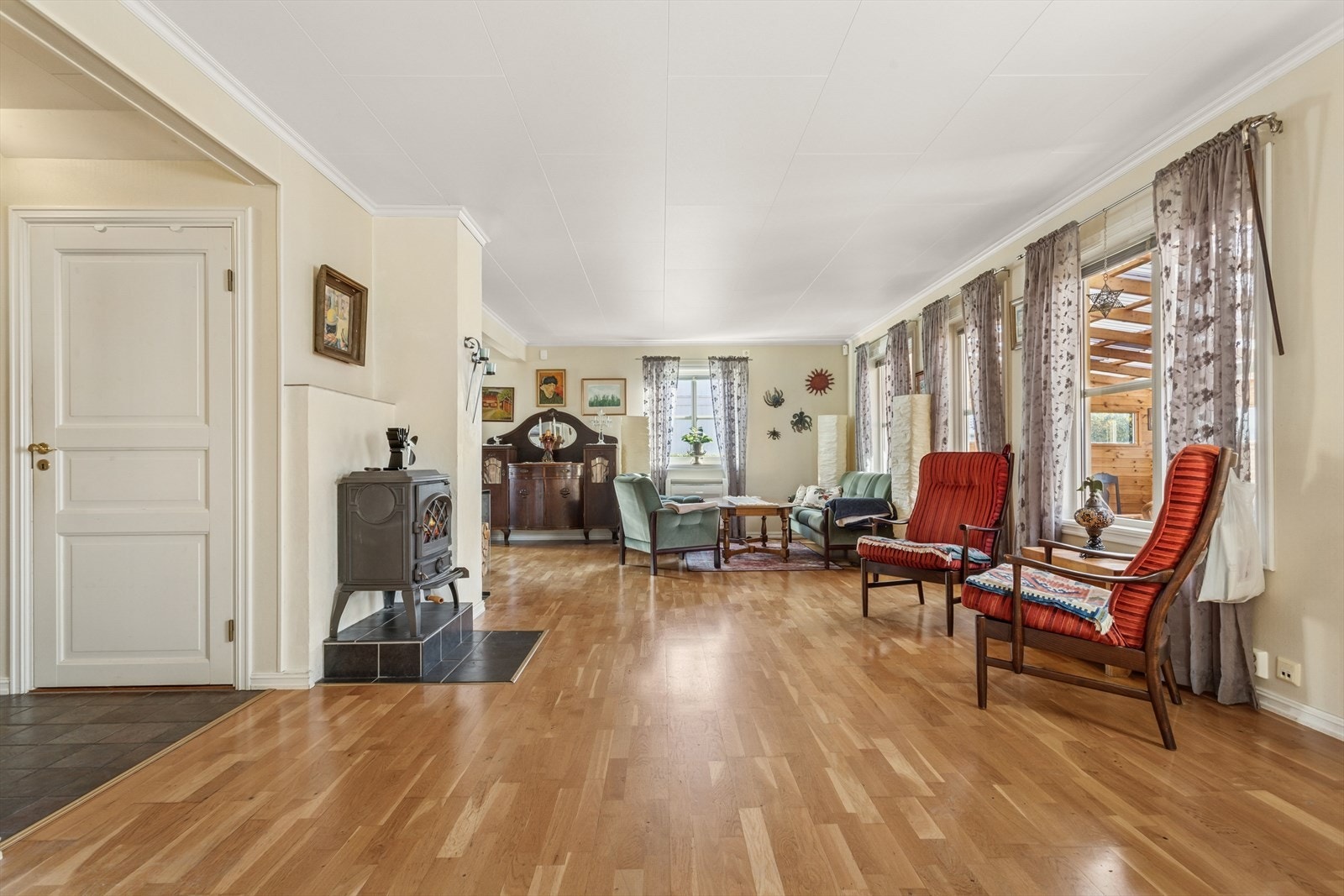 Vi beveger oss videre inn i en lys og koselig stue. Peisovnen bidrar til å varme opp både rom og stemning. Det er også etablert varmepumpe. Galleribilde