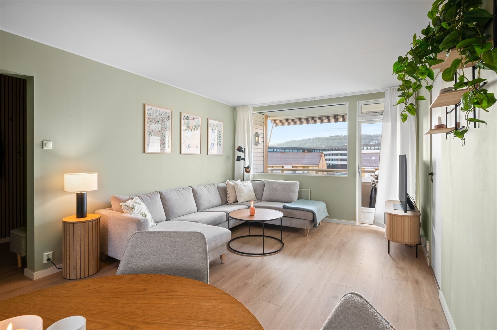 Boligens sosiale arena er lys og hyggelig med plass til stor sofagruppe og spisestuebord mot kjøkkenet. Galleribilde