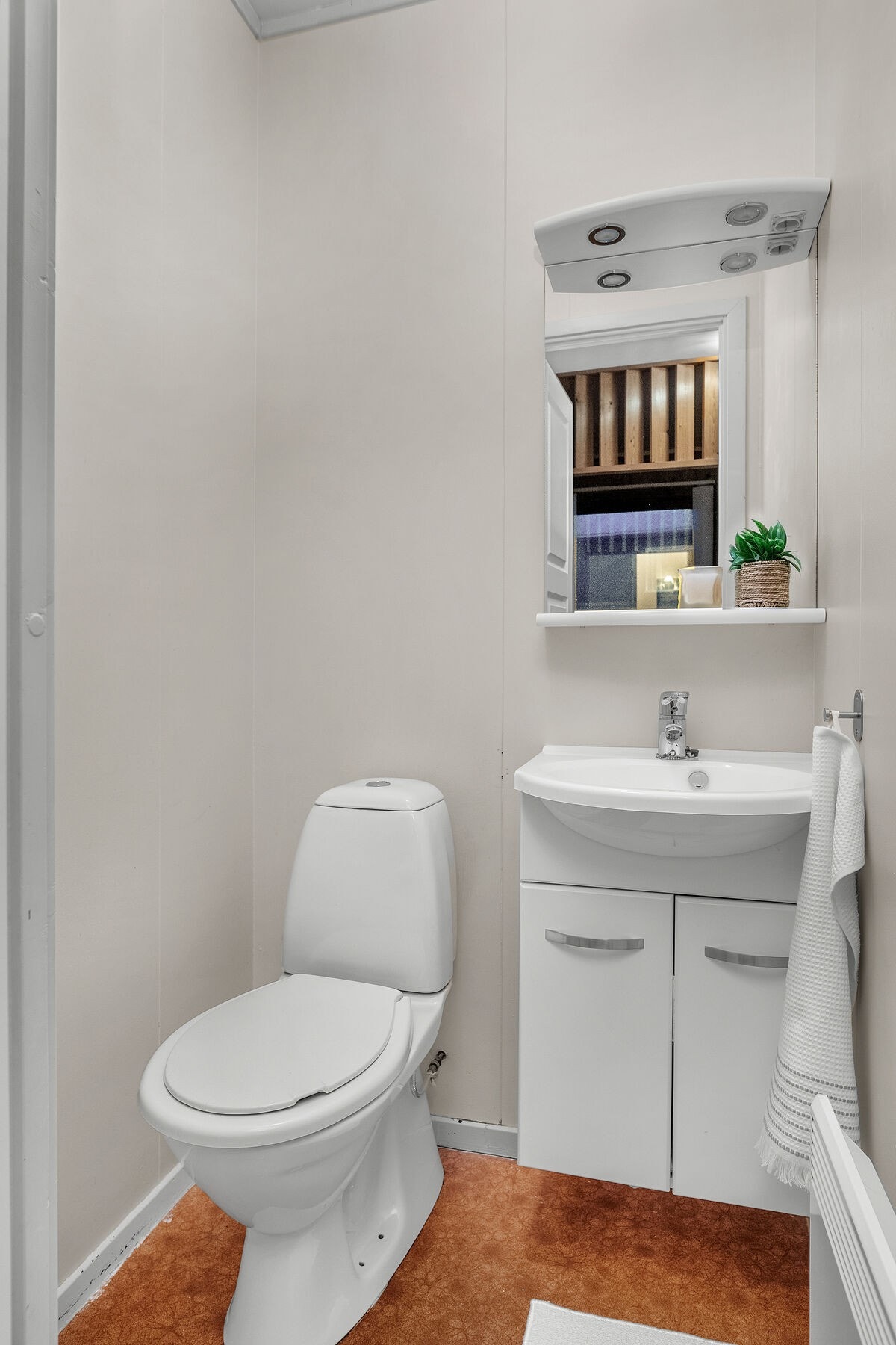 Separat toalettrom med servant på innredning og gulvmontert toalett. Galleribilde