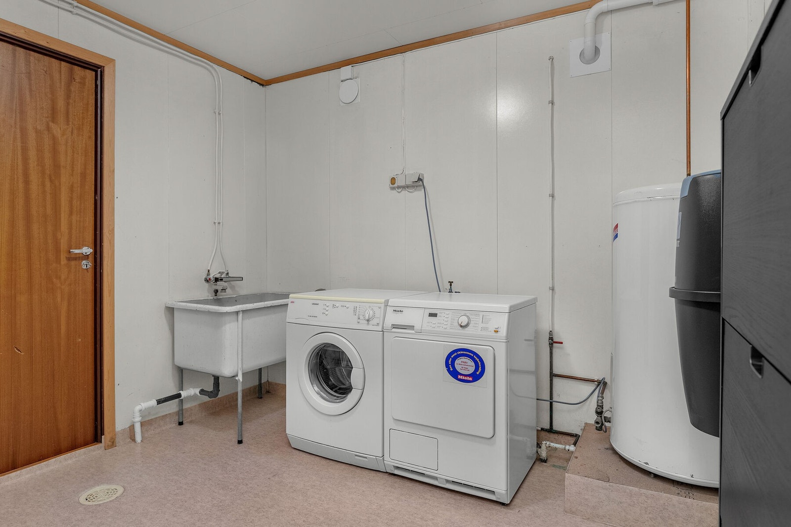 Vaskerom med opplegg for vaskemaskin og tørketrommel, samt skyllekar i plast. Galleribilde