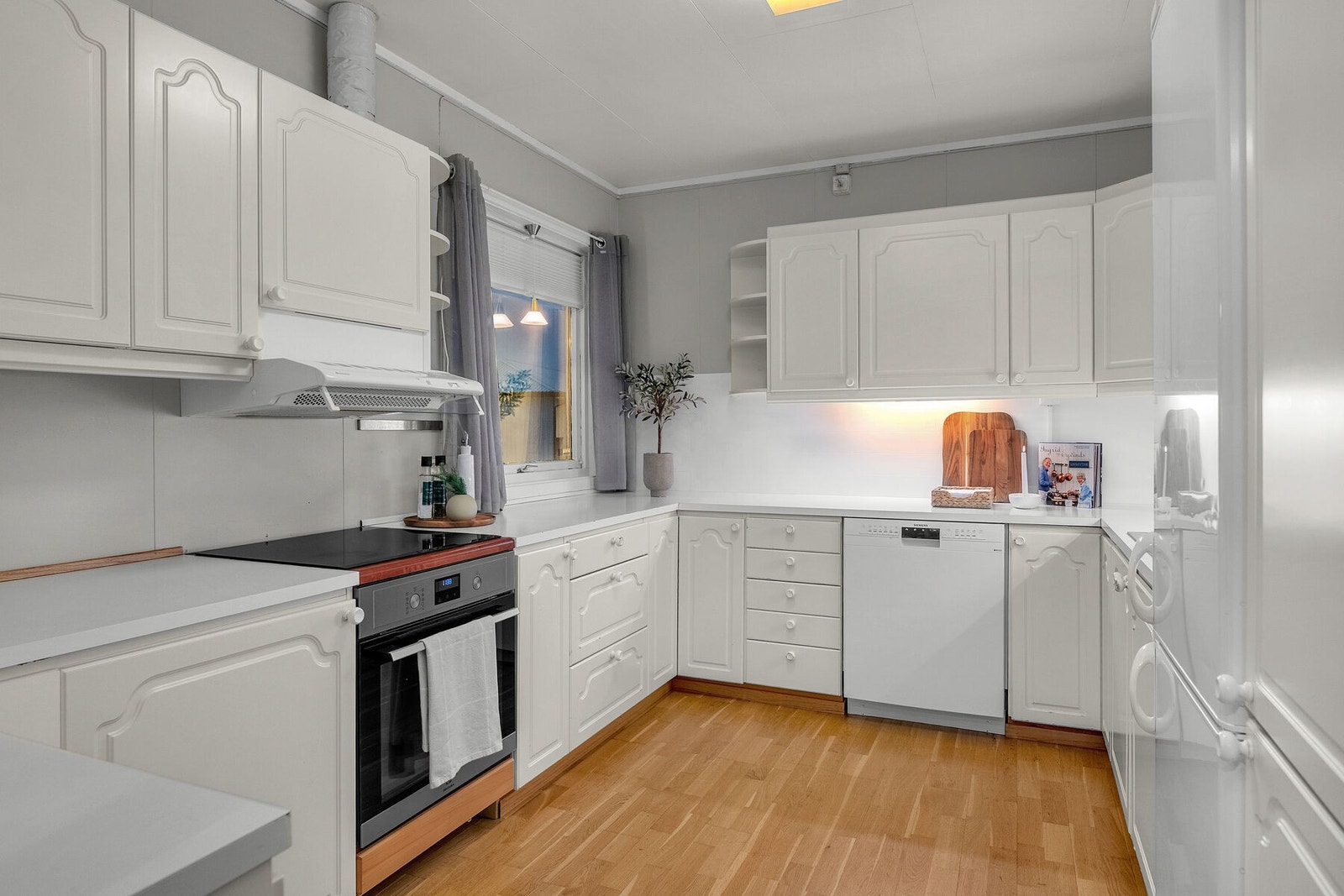 Tidløs kjøkkeninnredning med profilerte fronter og laminat benkeplate. Galleribilde