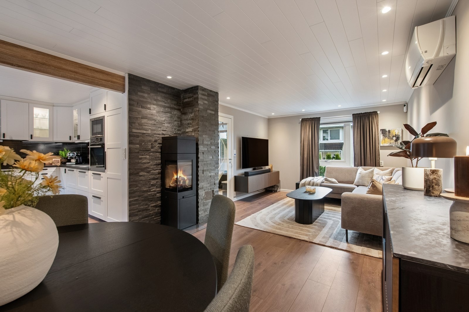 Stuen er lun og hyggelig innredet med peisovn og steinbelagt brannmur. Galleribilde