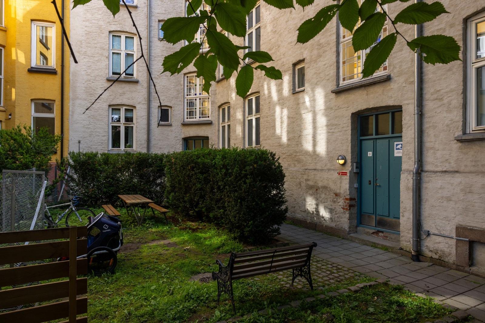 Bakgården er hyggelig opparbeidet med beplantning og sittebenk. Galleribilde