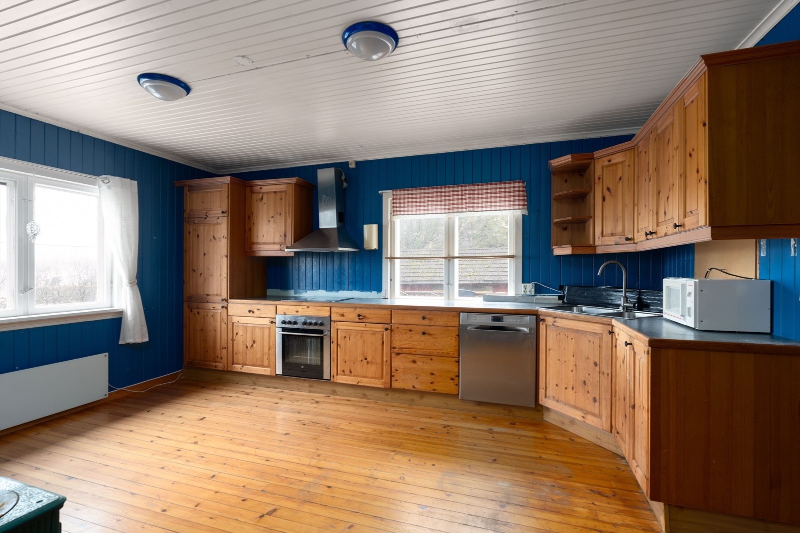 Kjøkkeninnredning med over- og underskap i heltre, laminat benkeplate med nedfelt oppvaskkum. Galleribilde