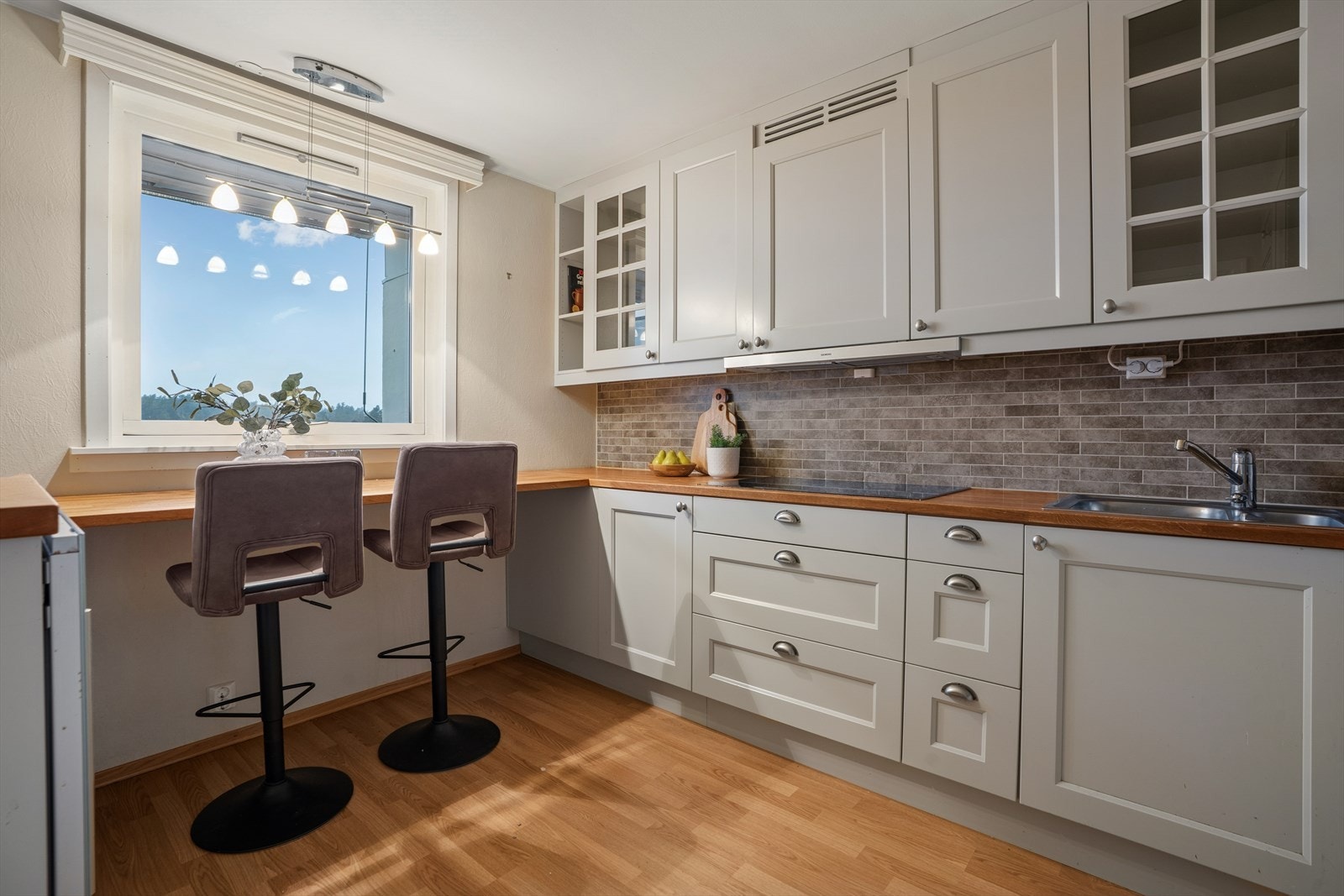 Kjøkkenet er praktisk og innbydende med innredning som har profilerte fronter og en benkeplate i heltre som gir et solid og tidløst preg. Galleribilde