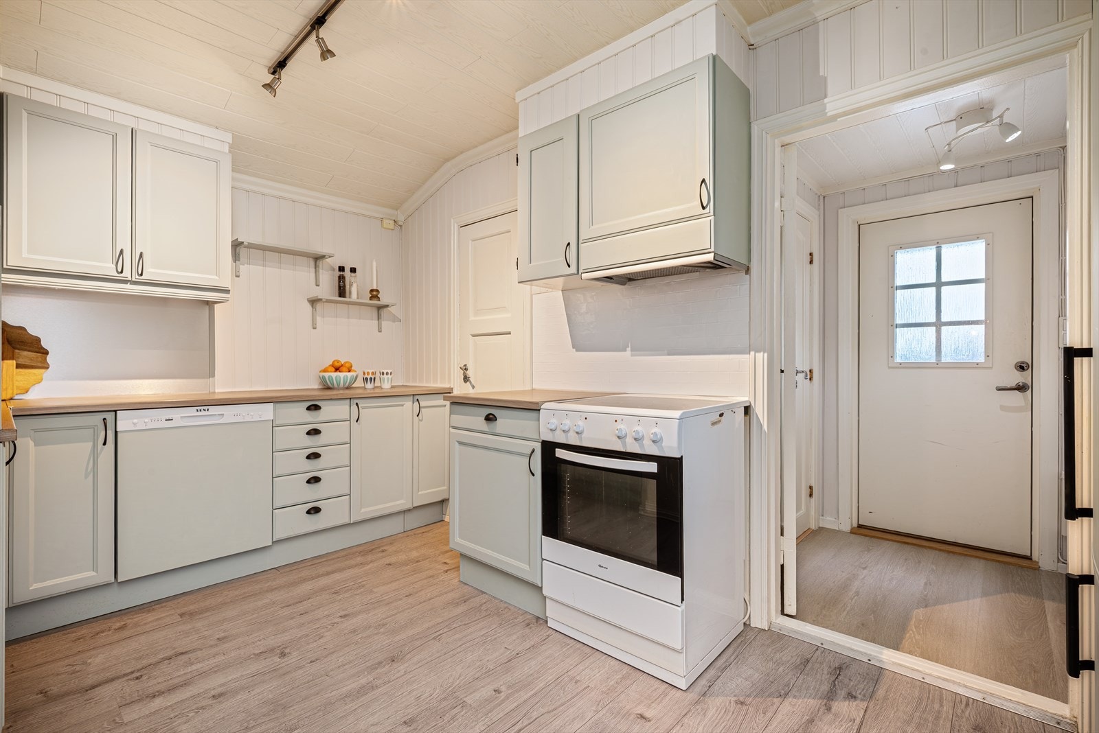 Fra kjøkkenet har man via vindfanget utgang til hagen på baksiden av huset. Galleribilde